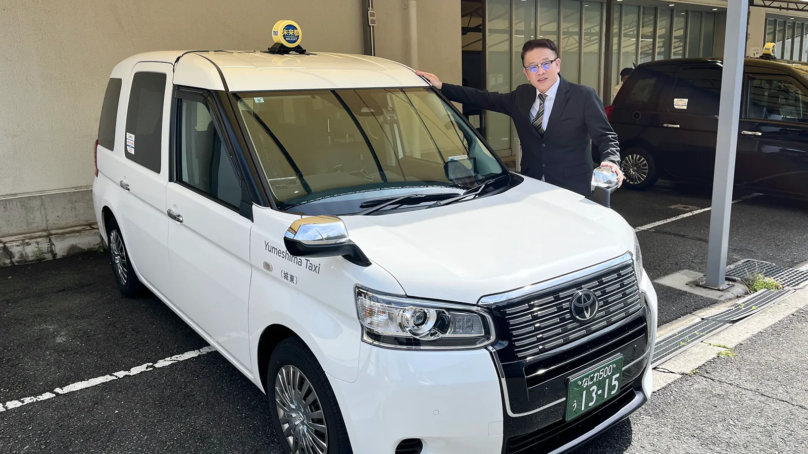 タクシーの前に立つY.O.さん