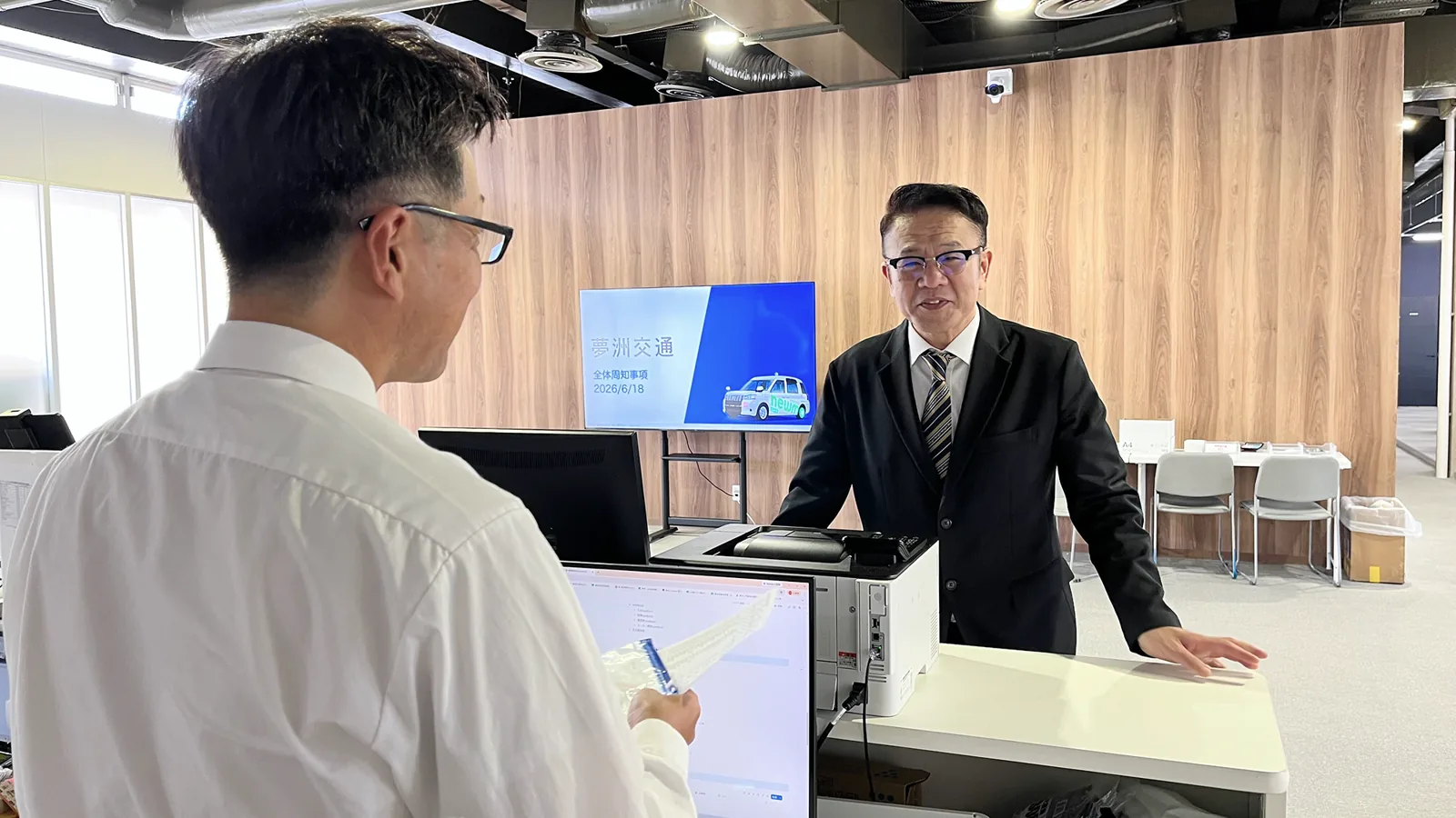 営業所で同僚と話すY.O.さん
